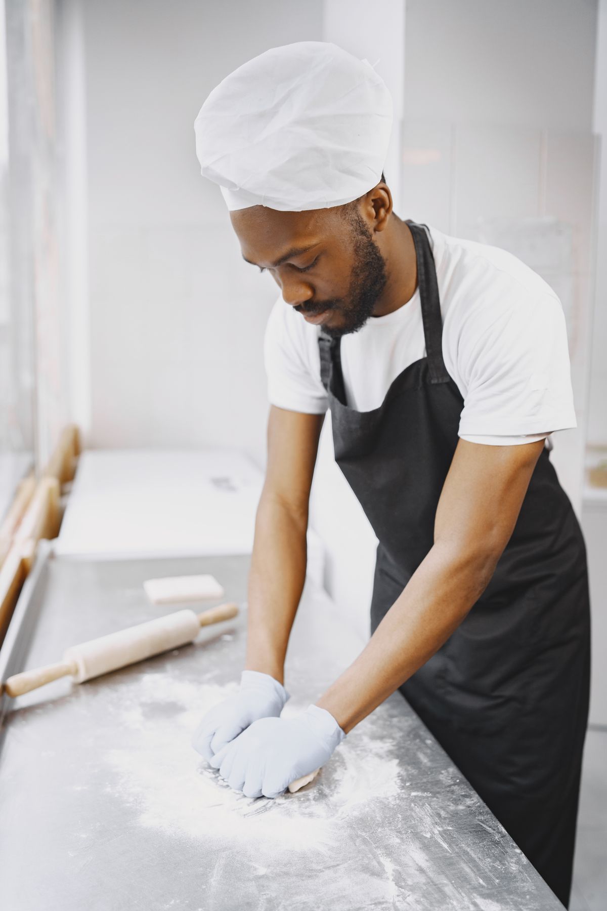 Un boulanger pétrit la pâte à la main sur un plan de travail fariné