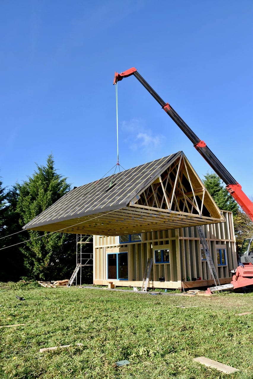 Une charpente en bois posée à la grue sur une maison en construction