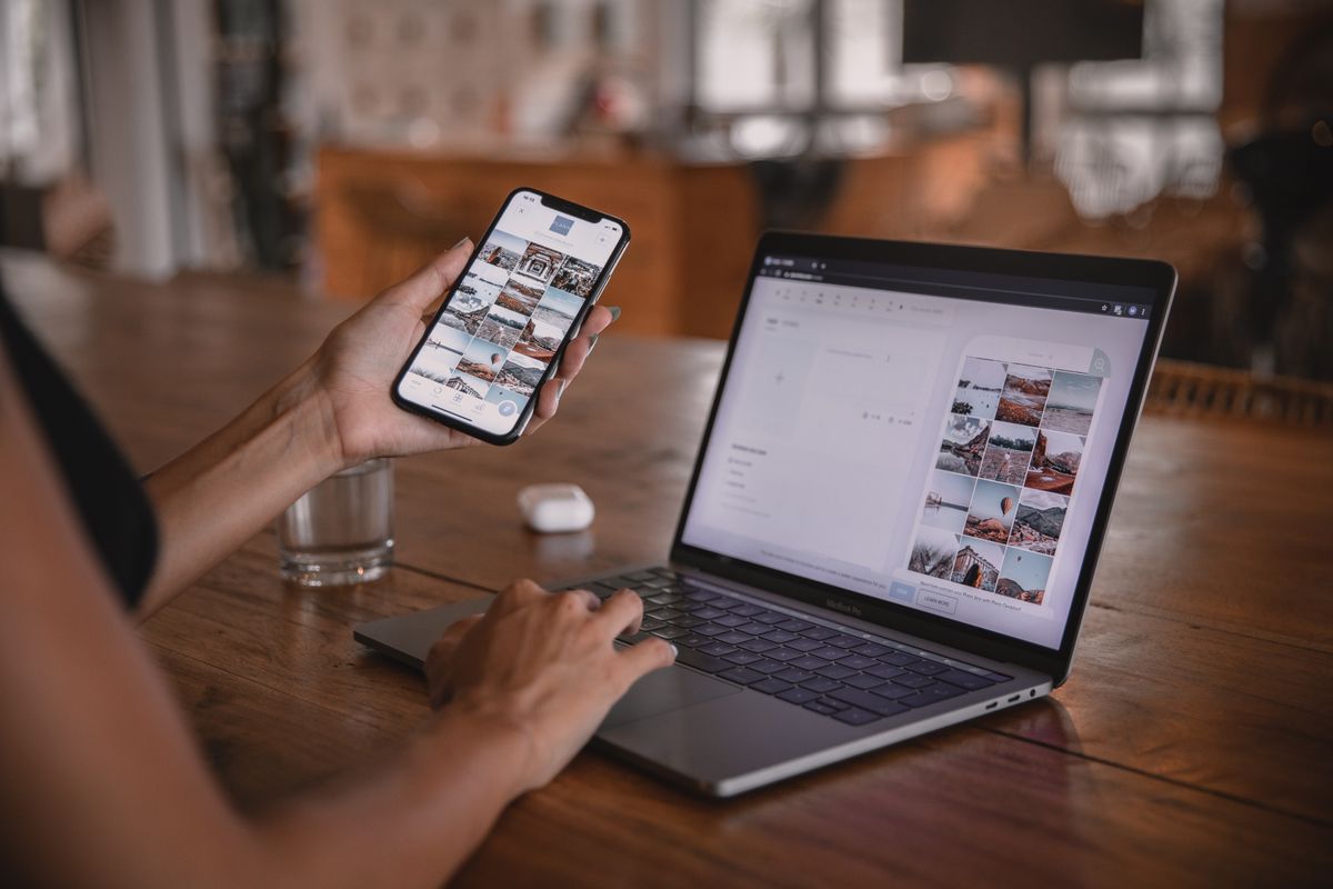 Une community manager travaille sur son smartphone et son ordinateur portable