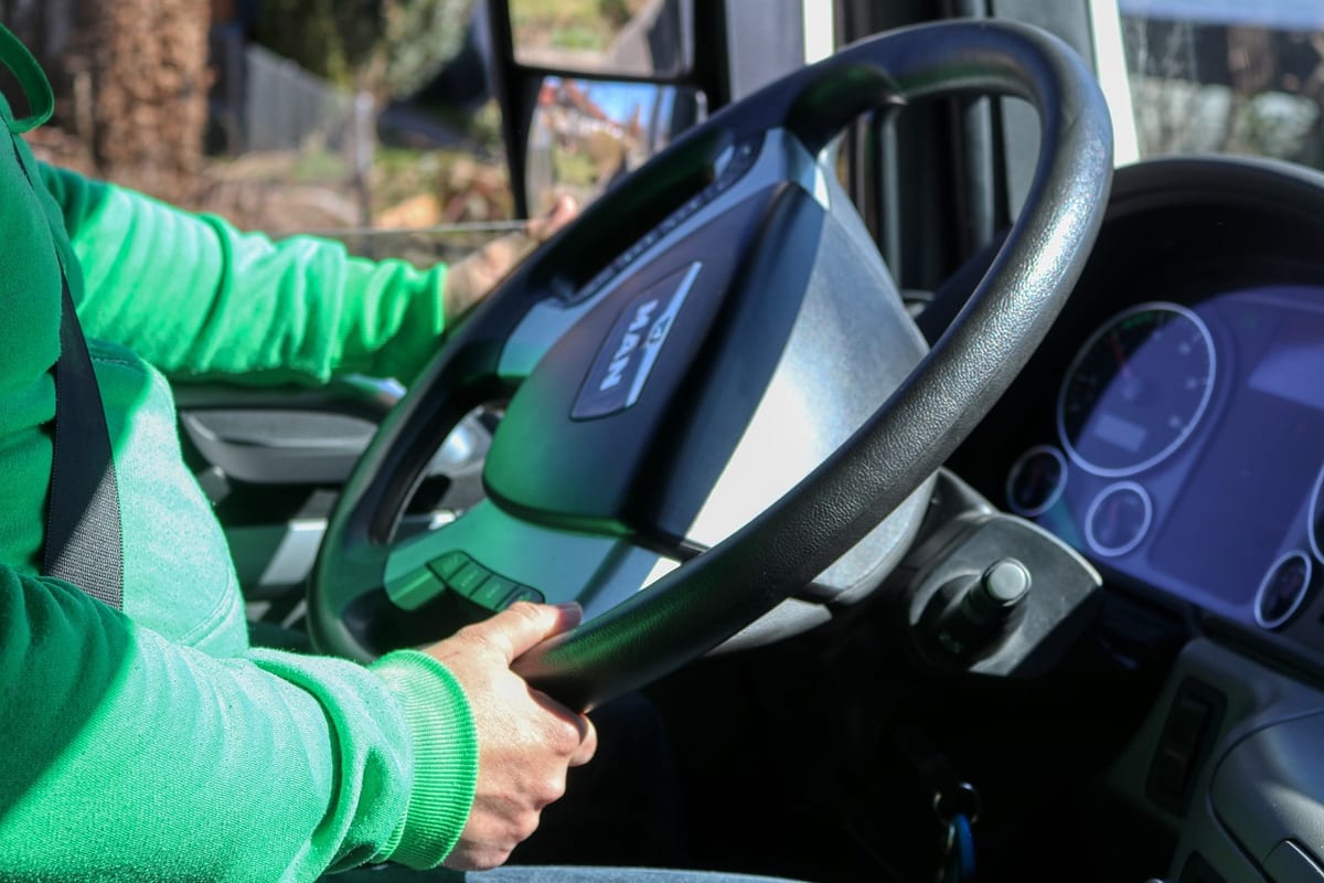 Une conductrice routière tient le volant de son poids lourd