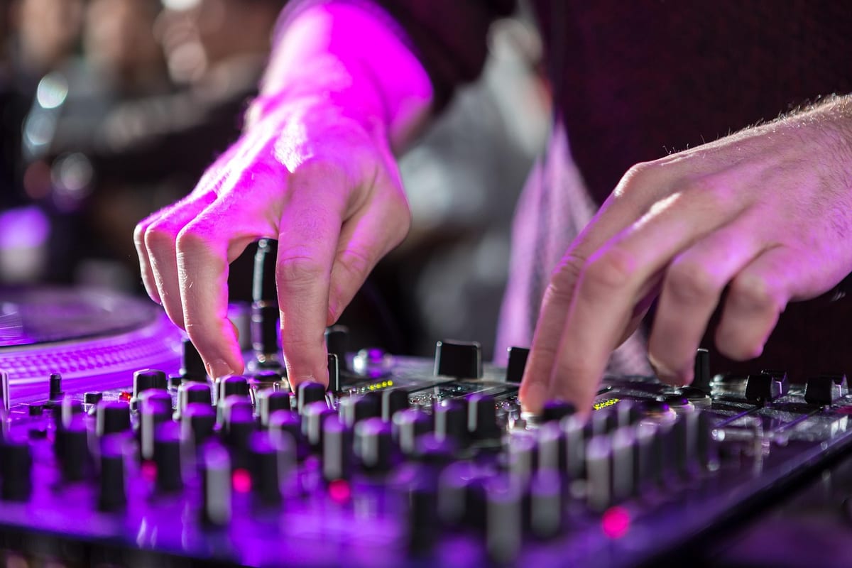 Une ingénieure du son règle les curseurs d'une table de mixage