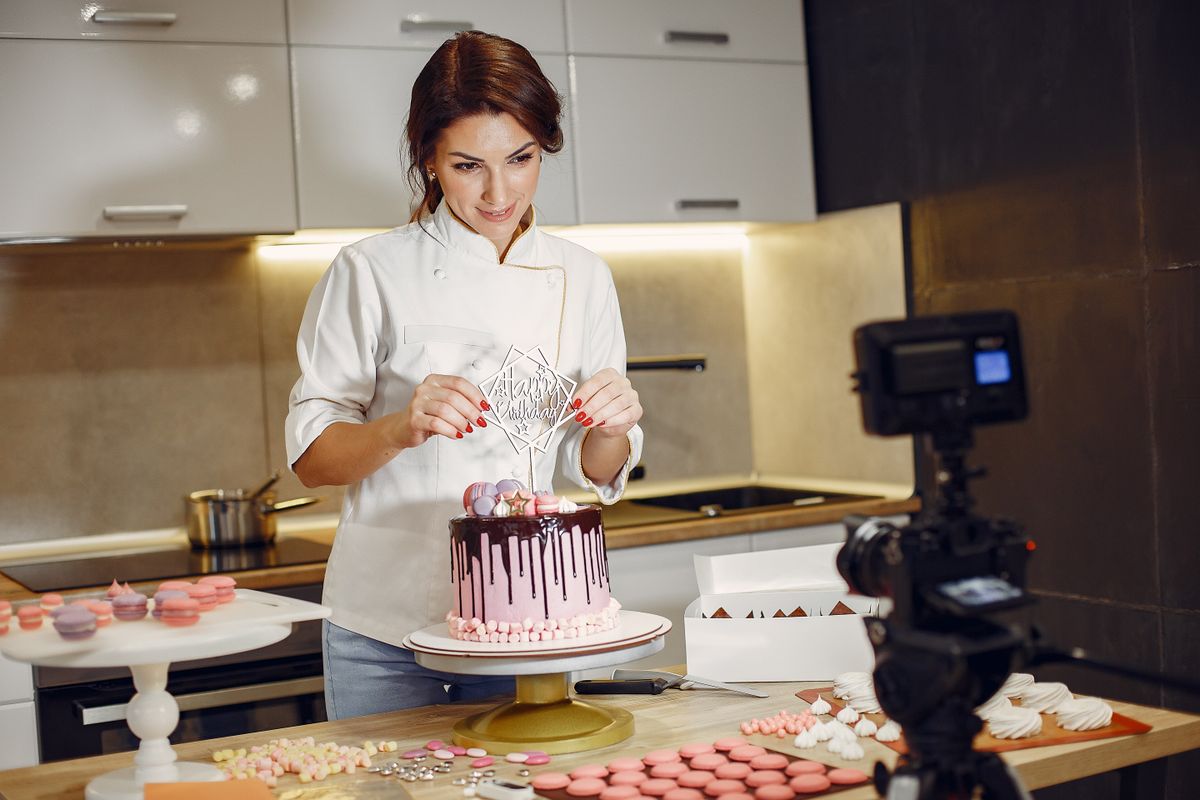Une pâtissière décore un gâteau avec précision dans une cuisine professionnelle