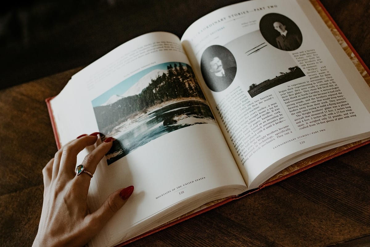 Une main tourne les pages d'un livre illustré
