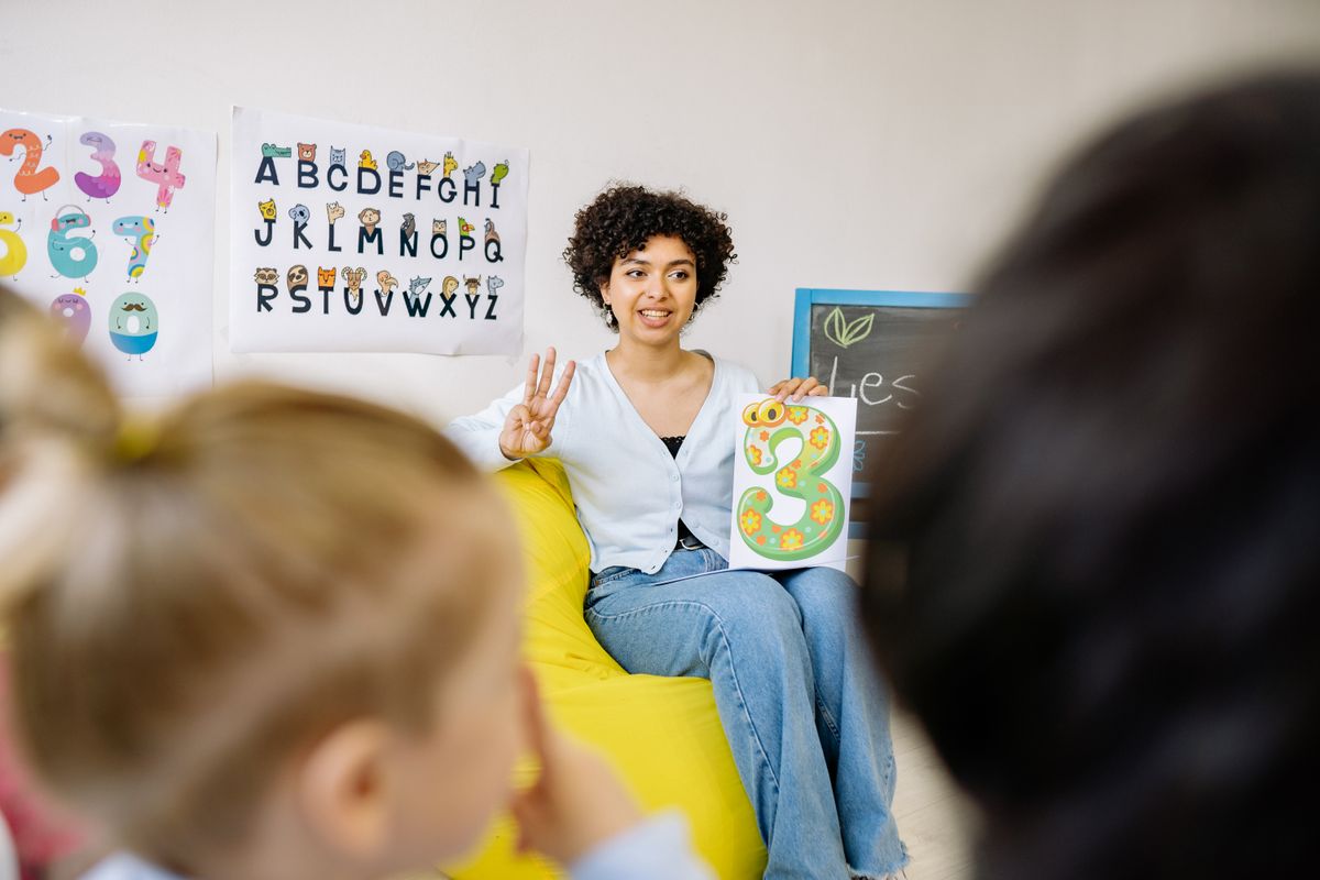 Une professeure des écoles anime une activité avec un groupe d'élèves en classe